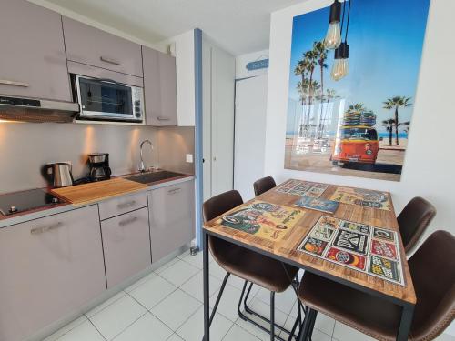 - une cuisine avec une table et des chaises en bois dans la chambre dans l'établissement REF 040 - Studio moderne et rénové pour quatre personnes vue port Crouesty ARZON, à Arzon