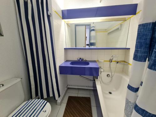 une salle de bain avec un lavabo bleu et des toilettes dans l'établissement REF 040 - Studio moderne et rénové pour quatre personnes vue port Crouesty ARZON, à Arzon