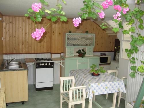 エゲルにあるCsaládi Vendégházのピンクの花が飾られたテーブル付きのキッチン
