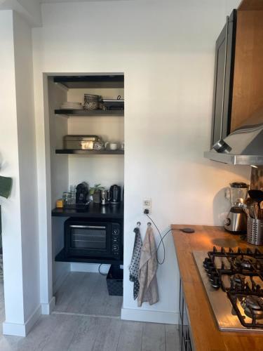 a kitchen with a counter and a microwave and a stove at Tastefull double story 2 bedroom appartment/house in Haarlem