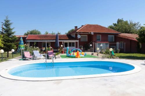 una pequeña piscina con parque infantil en un patio en Nature House Bulgaria en Radanovo