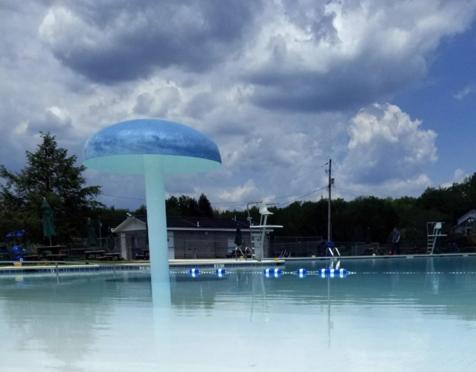 a blue pole in the middle of a swimming pool at Nature Escape Resort With Large Private Deck, Hot Tub, BBQ Grills, at Arrowhead Lake with 3 Pools, 4 Beaches at the Lakes and MORE in Thornhurst