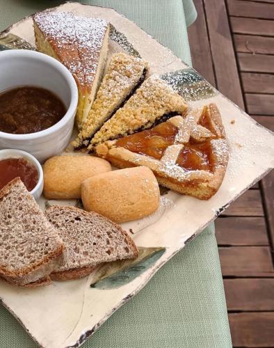 a plate of bread and dipping sauce and a plate of sandwiches at Locanda Del Viandante B&B in Anghiari