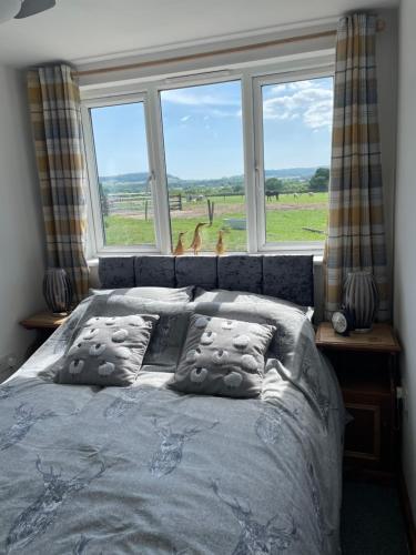 1 dormitorio con 1 cama y 2 ciervos en la ventana en Mallard s Retreat, en Blandford Forum