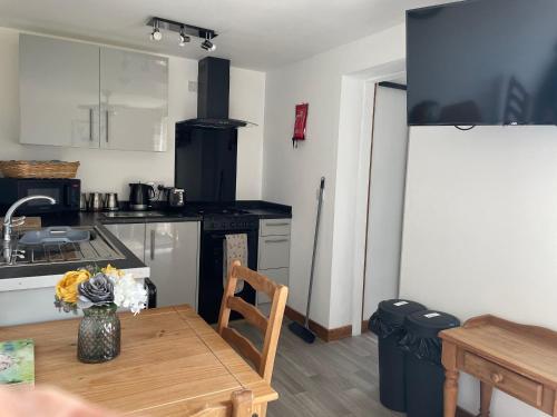 a kitchen with a wooden table and a kitchen with a stove at Mallard s Retreat in Blandford Forum