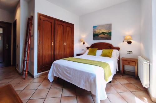 a bedroom with a large white bed with yellow pillows at Hotel Rural LAbadia de Sieste in Sieste