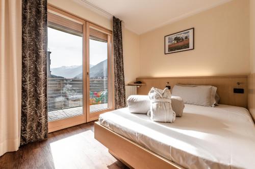 a bedroom with a bed and a large window at Ravelli Sporting in Mezzana