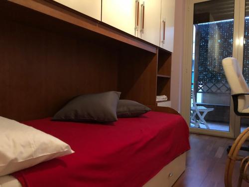 a bedroom with a bed with a red blanket and a window at Le Ortensie in centro e vicino al mare in Pescara
