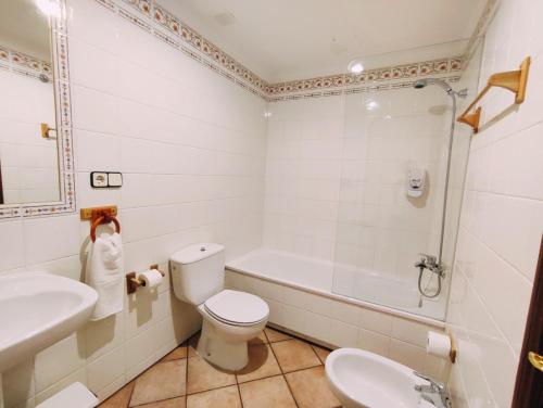 a bathroom with a toilet and a tub and a sink at Hotel Rural LAbadia de Sieste in Sieste