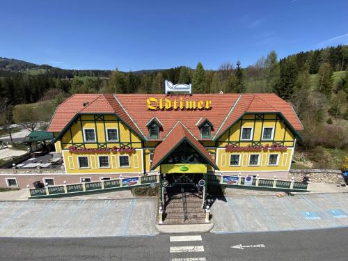 un bâtiment jaune avec un panneau en haut dans l'établissement Oldtimer Motel Pack, à Unterauerling