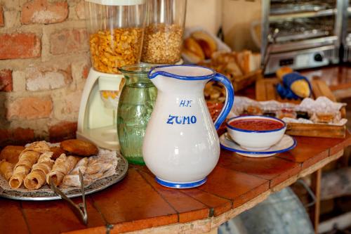 a counter with a jug of milk and a plate of food at Hotel Rural Hosteria Fontivieja TR-CC-195 in Losar de la Vera