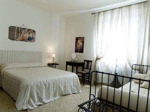 a bedroom with a bed and a chair and a window at La Rocca in Pergola