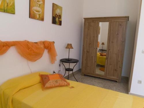 - une chambre avec un lit jaune et un miroir dans l'établissement La Rocca, à Pergola