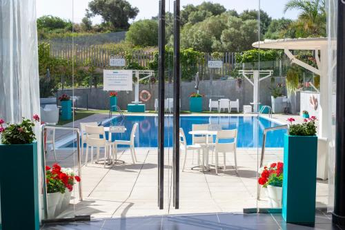 a swimming pool with tables and chairs next to a building at SALOU 4 YOU apartamentos in Salou