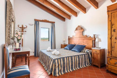 a bedroom with a bed and a table and a window at Villa Rafal Fort by Escape Home in Alaior