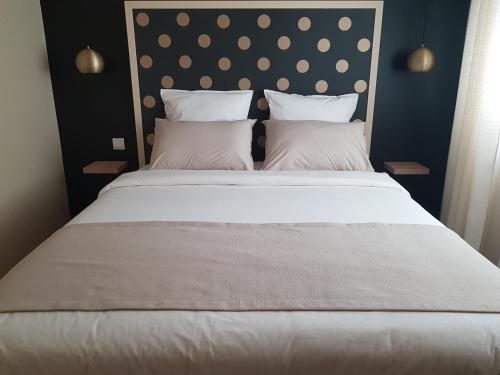 a bedroom with a large bed with white sheets and pillows at Les Moineaux de Crussol in Guilherand