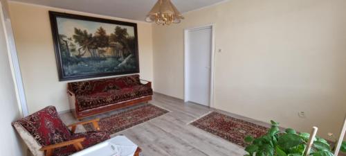 a living room with two chairs and a painting on the wall at Lovely 1 bedroom apartment in Miercurea Ciuc in Miercurea-Ciuc