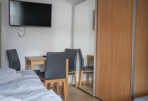 a room with a table and chairs and a television at Zwehrener Hof in Kassel