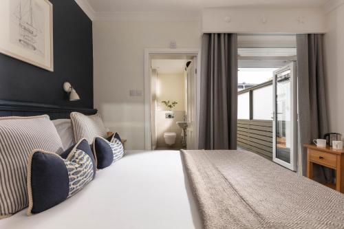 a bedroom with a large white bed with blue pillows at St Michaels Resort, Falmouth in Falmouth
