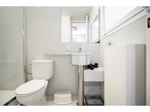 ein weißes Badezimmer mit Toilette und Waschbecken in der Unterkunft Espacioso Loft en Ponzano-Chamberí– Madrid in Madrid