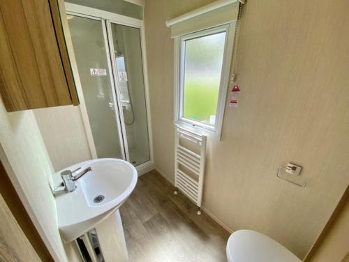 a bathroom with a sink and a toilet and a window at Waterside Holiday Park in Goodrington
