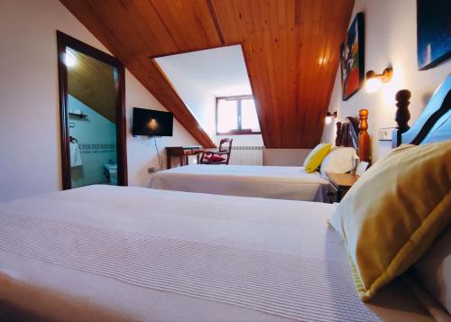 a hotel room with two beds and a tv at Hotel Rural LAbadia de Sieste in Sieste