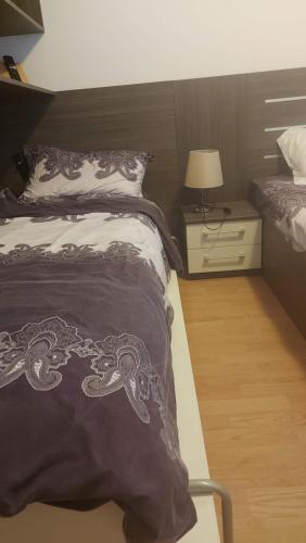 a bedroom with a bed and a night stand with a lamp at Апартаменты Aphrodite Roce in Sunny Beach