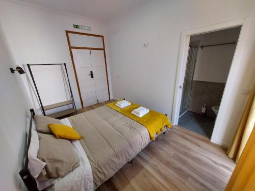 a bedroom with a bed with a yellow blanket at Wolley - Peniche GuestHouse 2 in Peniche