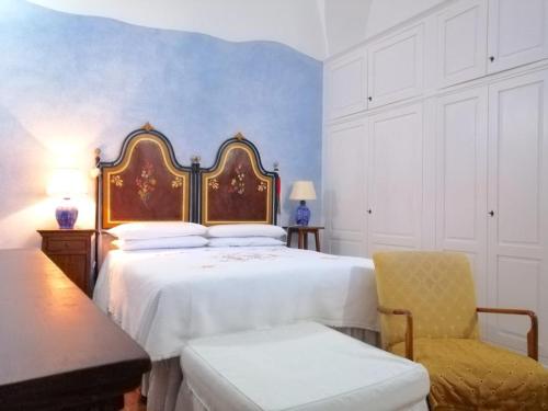 een slaapkamer met een groot bed en een stoel bij Anticadimora Dei Pepe in Salve