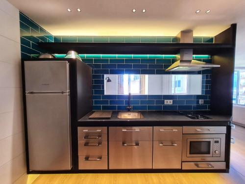 una cucina con frigorifero in acciaio inossidabile e piastrelle blu di Chayofa Central a Santa Cruz de Tenerife