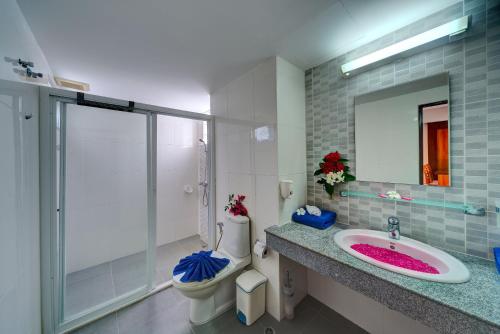 W łazience znajduje się umywalka, toaleta i lustro. w obiekcie Krabi Apartment-SHA Extra Plus w Aonang Beach