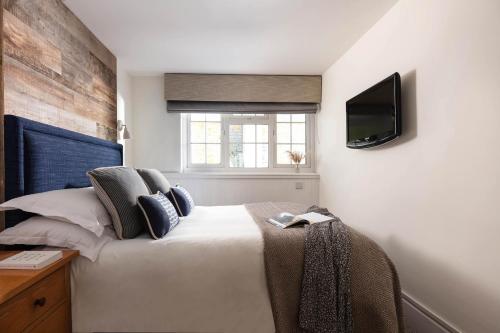 a bedroom with a bed and a tv on the wall at St Michaels Resort, Falmouth in Falmouth