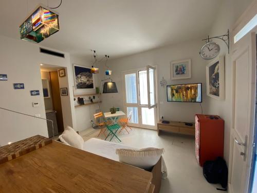 un soggiorno con tavolo e frigorifero di Dal Notaio, Appartamento Con Terrazza a Marettimo