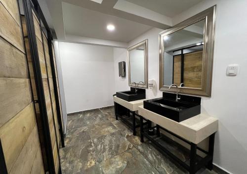 a bathroom with two sinks and a mirror at Hotel Momotus Cocora in Salento