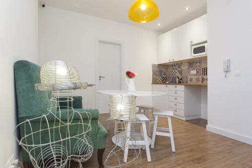 a living room with a table and a green chair at Lisbon Old Town Guest House in Lisbon