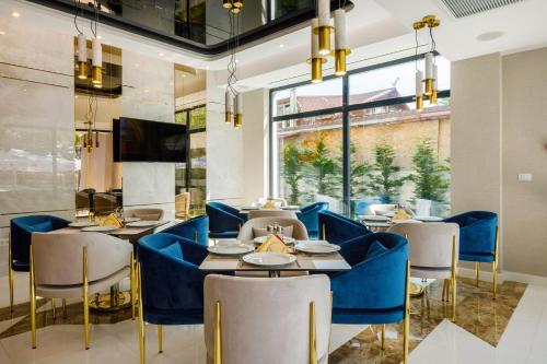 ママイアにあるOnal Boutique Hotelierの青い椅子とテーブル、大きな窓が備わるレストラン