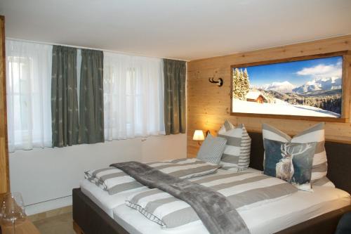 a bedroom with a large bed with a picture on the wall at Ferienwohnung Lechraum in Landsberg am Lech in Landsberg am Lech