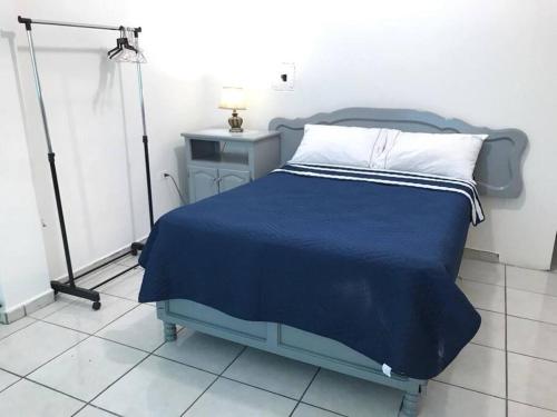 a bedroom with a blue bed with a blue blanket at Cerca del IMSS Depa OtancahuiBerna (Facturable) in Ciudad Obregón