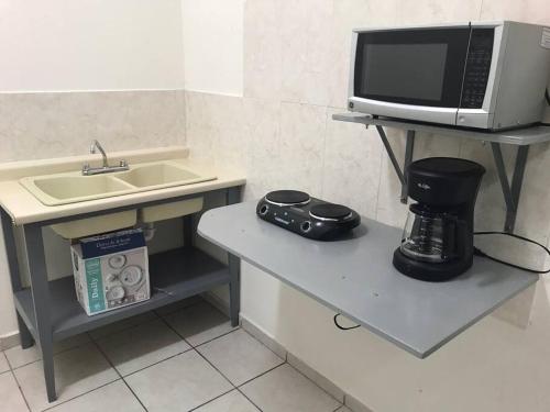 a small kitchen with a sink and a microwave at Cerca del IMSS Depa OtancahuiBerna (Facturable) in Ciudad Obregón