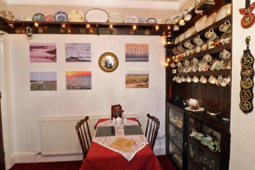 a dining room with a table and plates on the wall at Rosamaly Guesthouse in Hunstanton