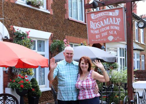 a man and a woman standing in front of a building at Rosamaly Guesthouse in Hunstanton