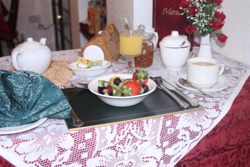 a tray with a bowl of fruit on a table at Rosamaly Guesthouse in Hunstanton