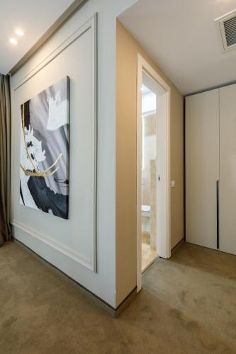 a hallway with a painting on the wall and a door at Onal Boutique Hotelier in Mamaia