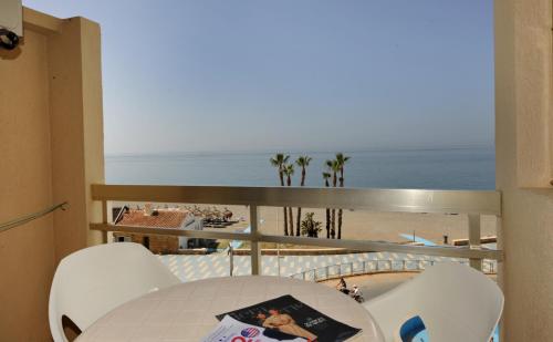 a balcony with a table and chairs and the ocean at Chinasol Suites in Almuñécar