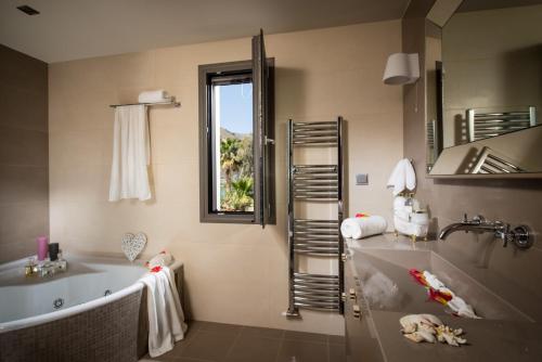 baño con bañera, lavabo y ventana en Villa Crete, en Hersonissos