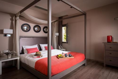 a bedroom with a canopy bed with a tray of food on it at Villa Belamar in Hersonissos