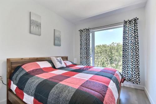 1 dormitorio con cama y ventana grande en GOOD VIBES ONLY -Modern and spacious 2 bedroom condo 4 beds FREE PARKING, GYM en Quebec