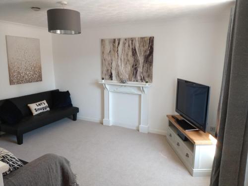 a living room with a television and a couch at Stamford Redcot Gardens Stylish 2 bed Family town house with parking in Lincolnshire