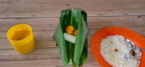 uma mesa com um recipiente de alimentos e um prato de arroz em Bribri ù sule em Suretka