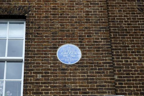 a brick wall with a plaque on the side of a building at The Royal Foundation of St Katharine in London